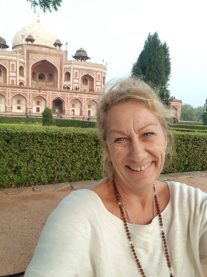 Woman in front of a historical building with detailed architecture.