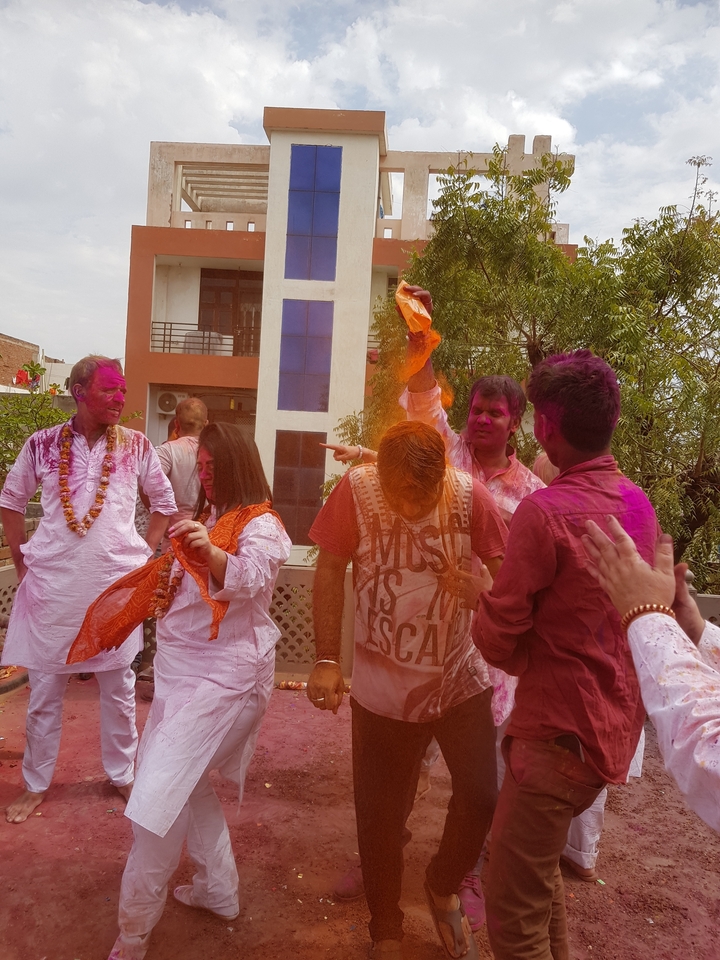 Group of people celebrating Holi with colored powder.