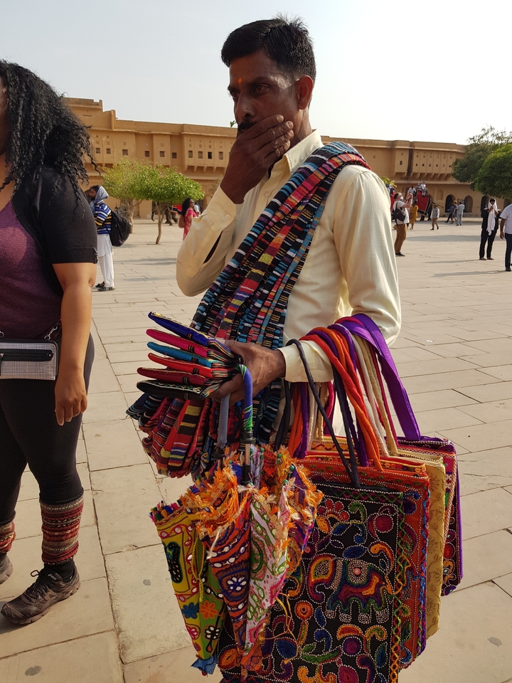 Person selling colorful fabric items.