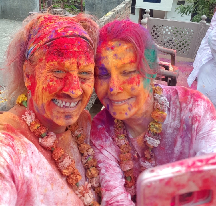 Two people celebrating Holi with colorful powder on their faces.