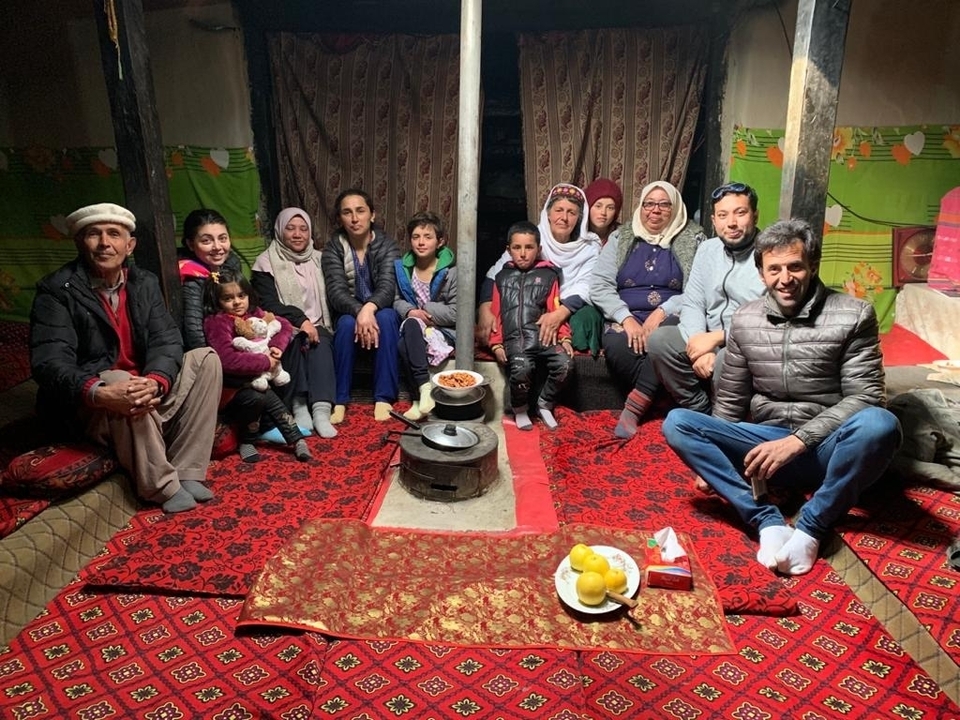 Family seated together inside a home with a traditional interior.