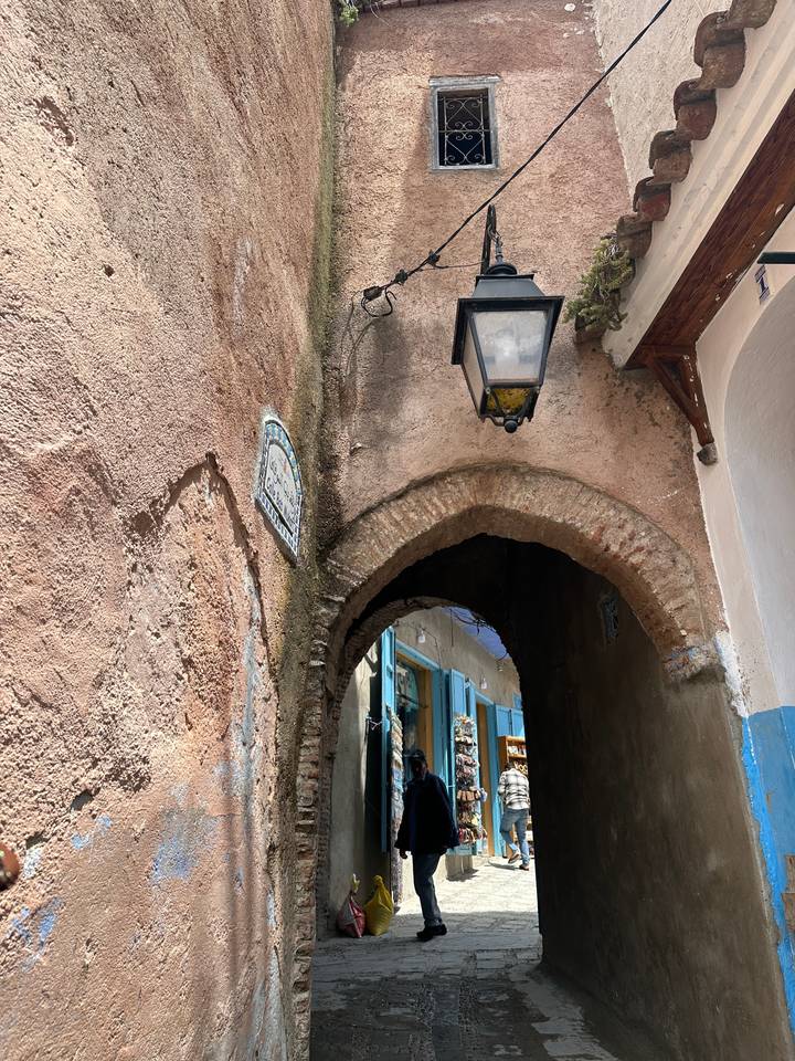 Rustic archway with view of a narrow street.