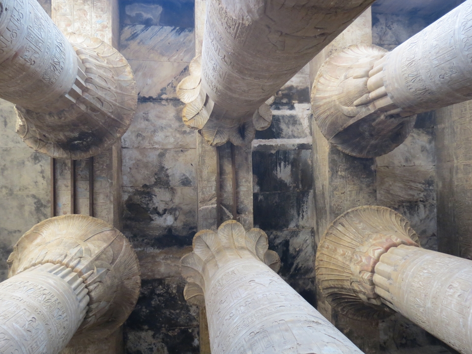 Detailed carvings of lotus flower columns at an Egyptian temple.
