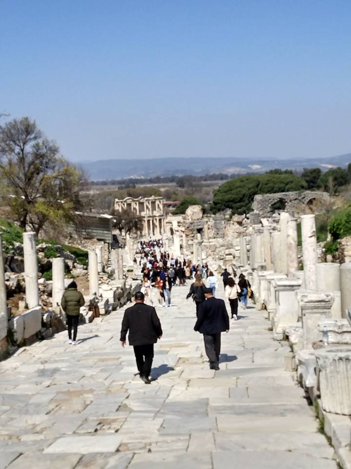 Des gens qui marchent le long d'une rue pavée historique.