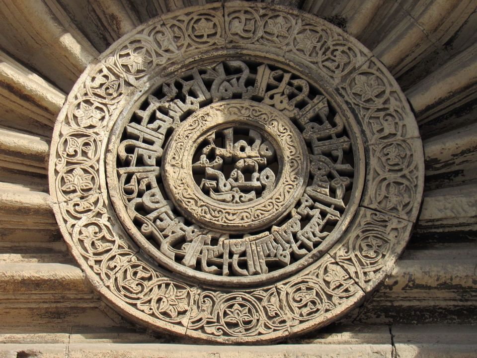 Close-up of intricate carvings on a circular stone with detailed inscriptions.