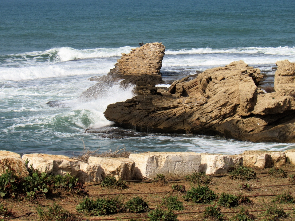 Rugged rocky coastline with waves crashing against rocks.