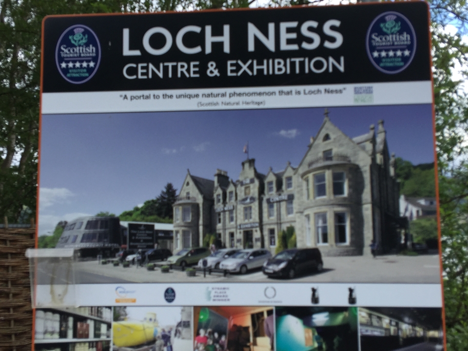 An exhibition center with parked cars and a sign for Loch Ness.