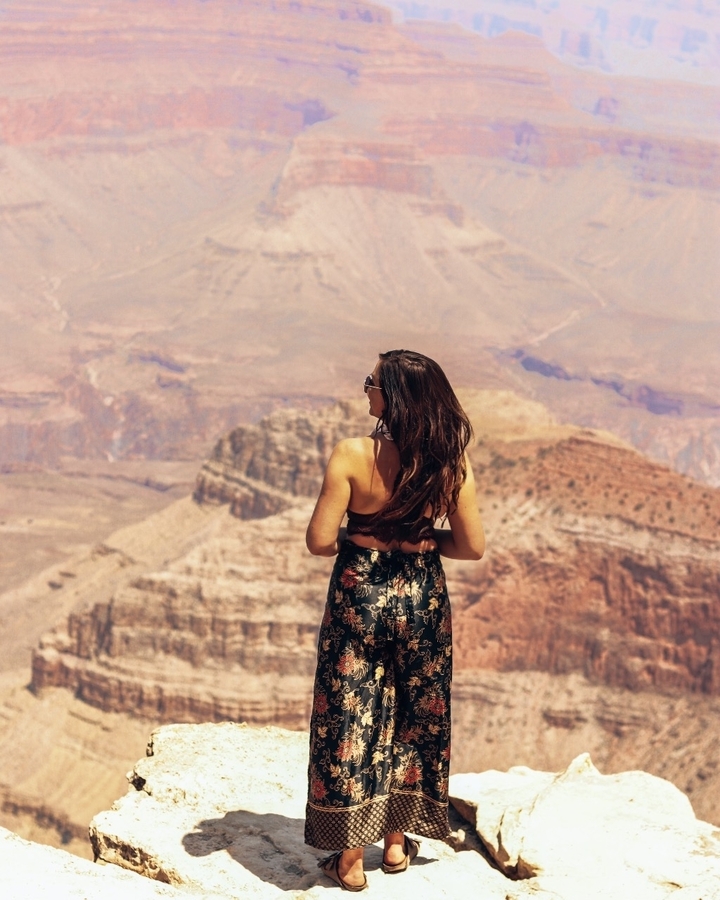 Woman standing at the edge of a canyon landscape.