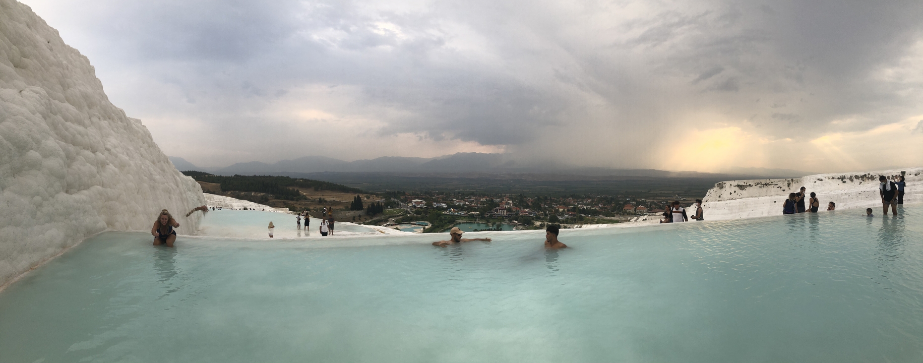 Piscines de travertin avec des personnes qui se détendent à l'intérieur.