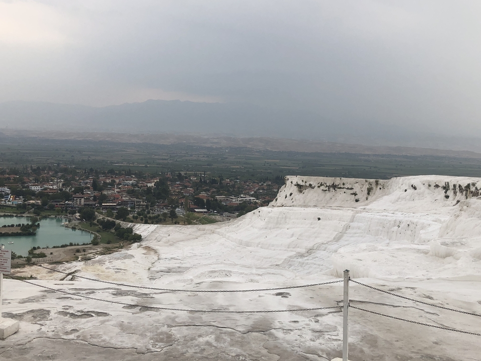 Terrasses naturelles de travertin surplombant une ville.
