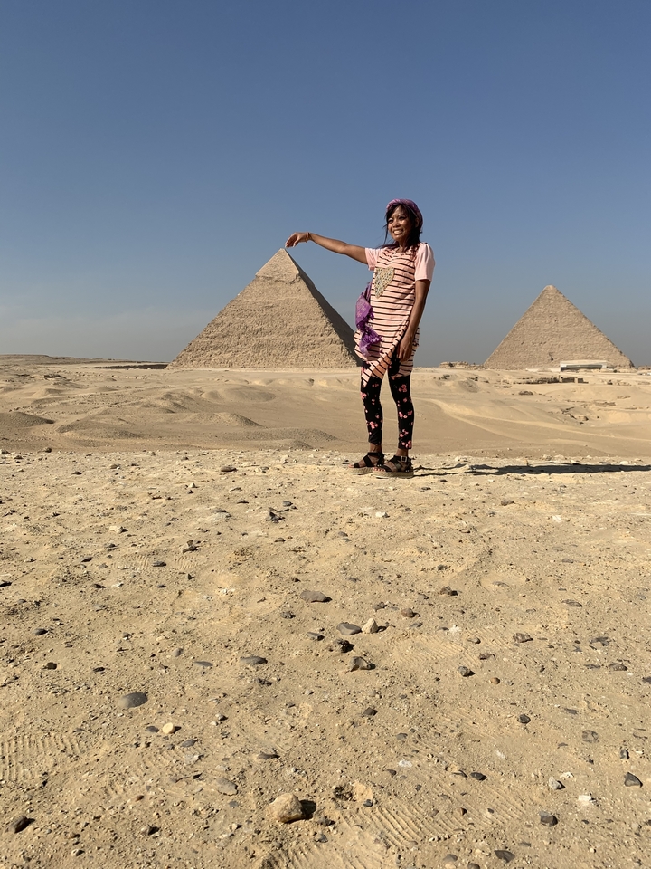 Personne debout devant les pyramides de Gizeh.
