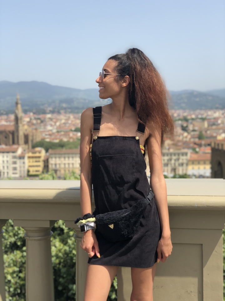 Woman standing with a skyline view in the background.