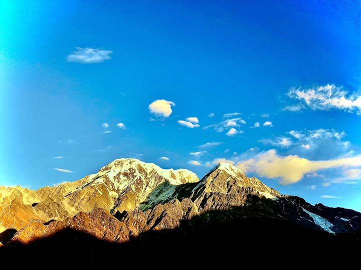 Besneeuwde bergen onder een diepblauwe hemel.