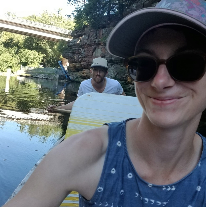 People on a boat in a river with trees in the background.