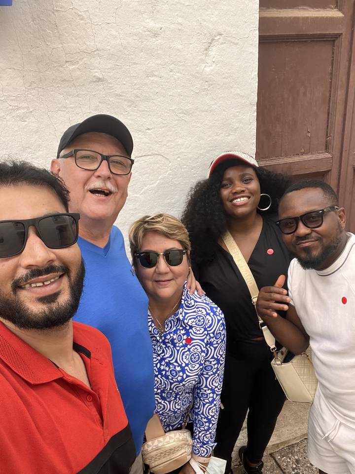 Five people standing together smiling.