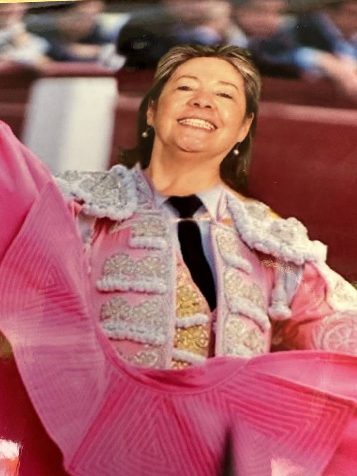 Person in traditional attire smiling broadly.