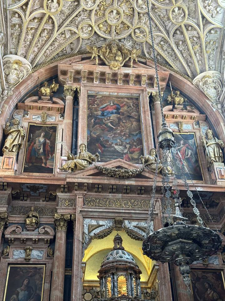 Intricate ceiling with ornate designs and a chandelier.