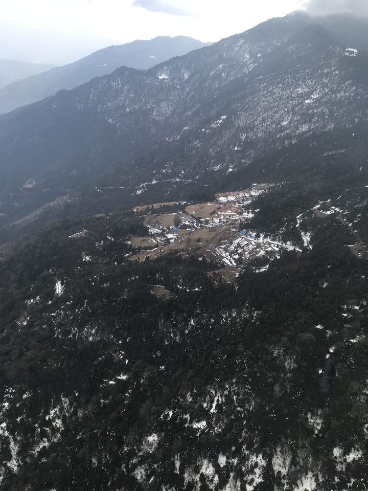 Paysage montagneux enneigé avec des habitations dispersées.