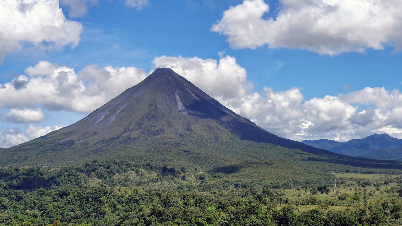 Arenal Volcano towering over lush forests.