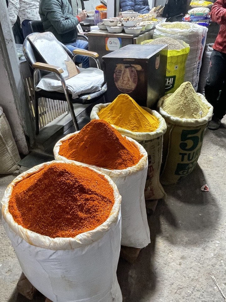Sacks of vibrantly colored spices on display.