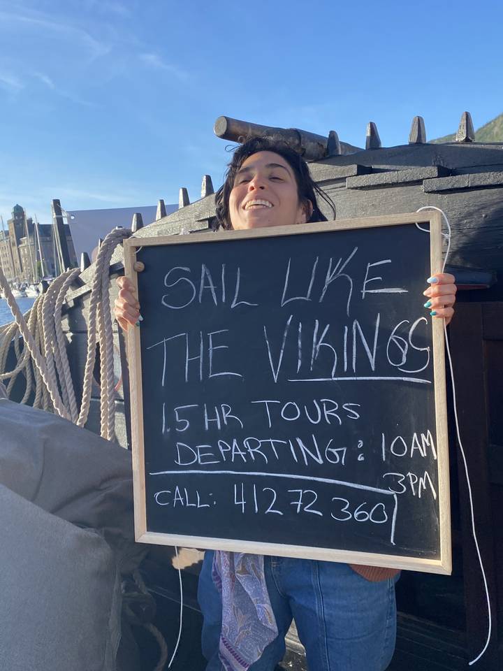 Person holding a sign about Viking sailing tours.