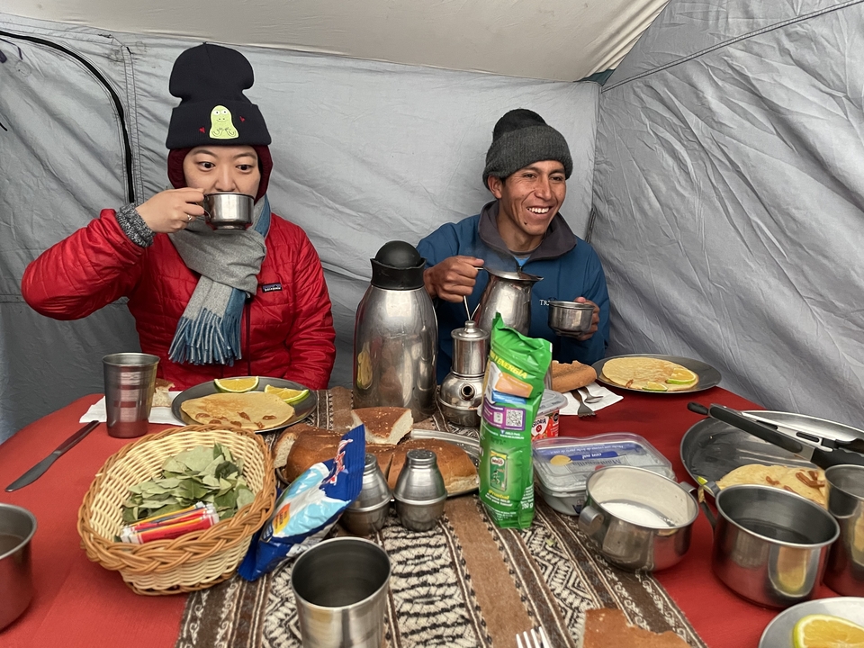 Two people enjoying a meal inside a tent