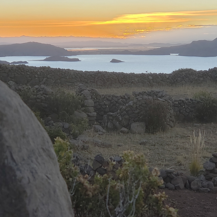 Stone fences and a body of water with islands in the background.