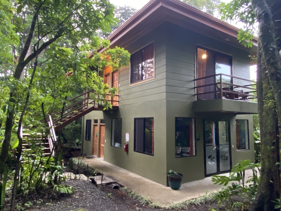 Two-story house surrounded by trees.