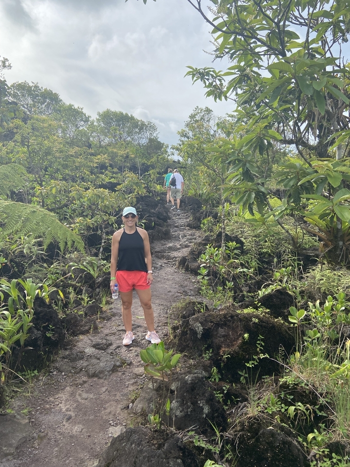 Person hiking on a rocky trail with vegetation.