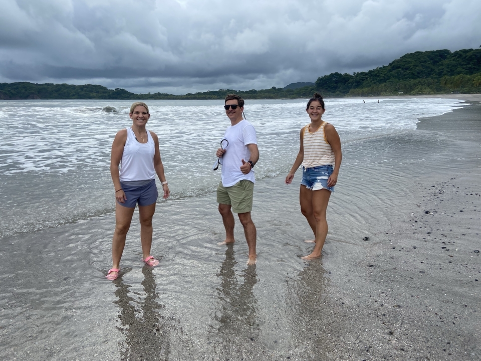 People standing on a beach with waves.