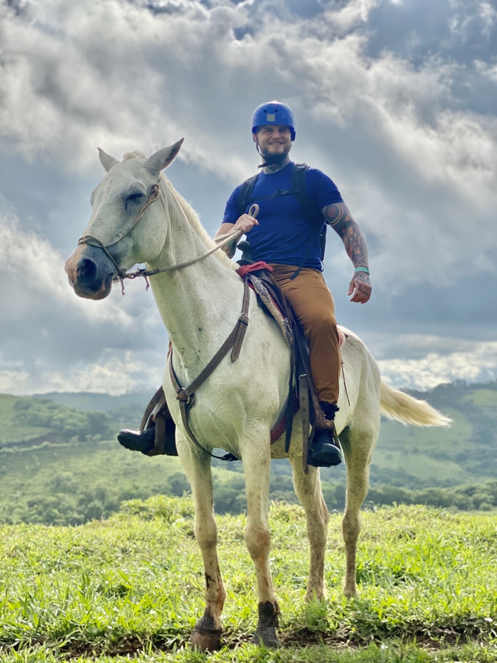Person on horseback in a scenic rural setting.