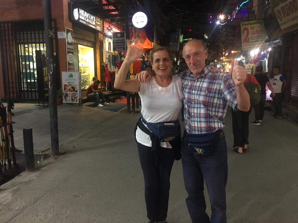 Two people in a busy street market at night.