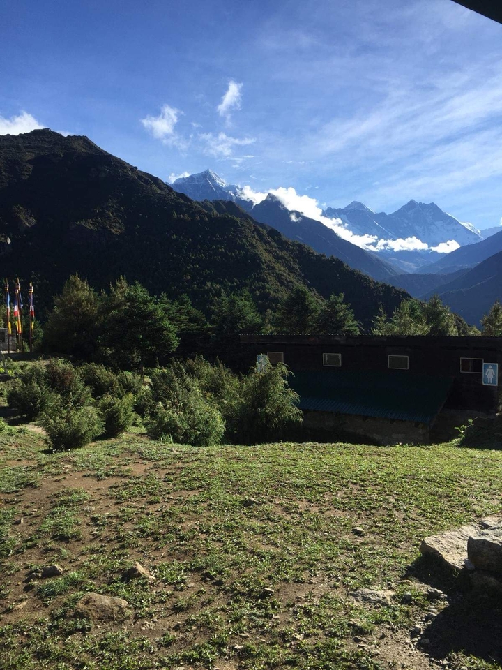 Mountains and forest landscape with a building in the foreground.