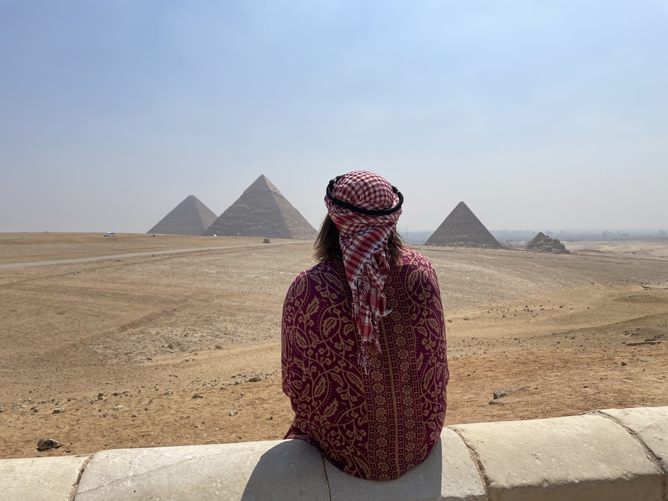 Person gazing at the Pyramids of Giza from a distance.