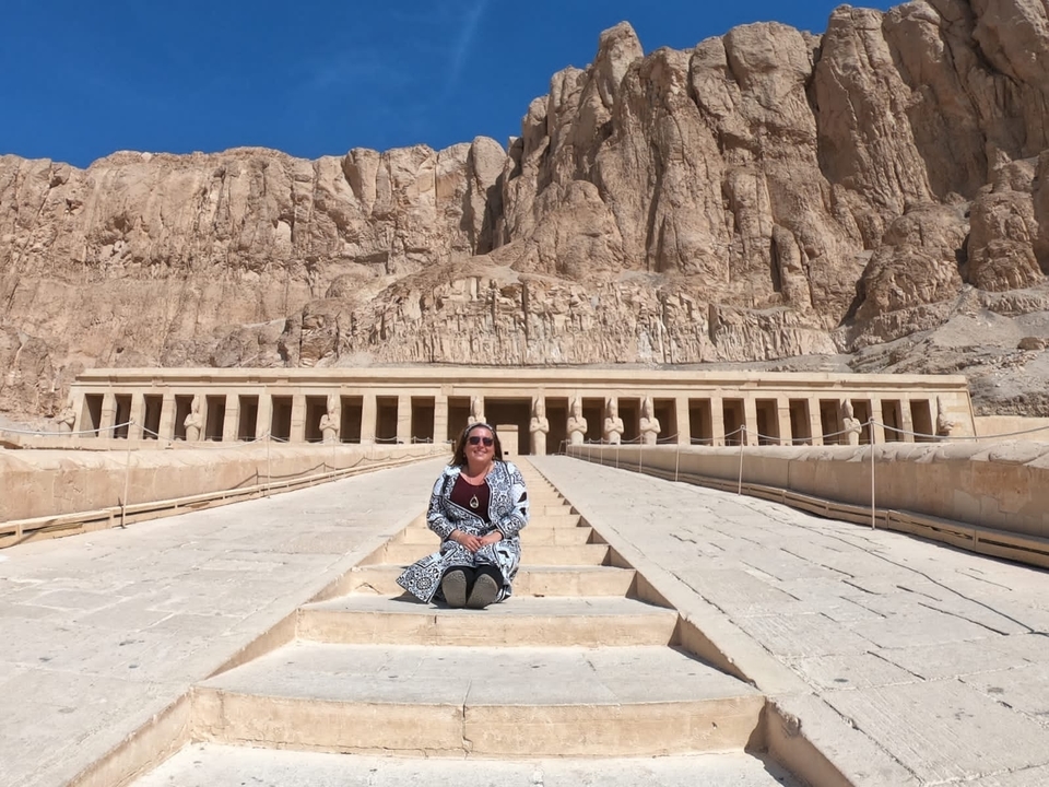 Person sitting in front of a monumental ancient temple structure.
