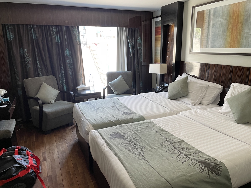 Hotel room with twin beds and a seating area.