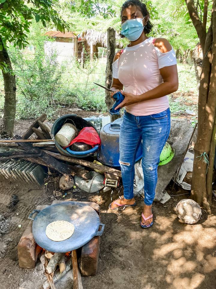 Close-up of person with assorted containers and rubbish in a natural setting.