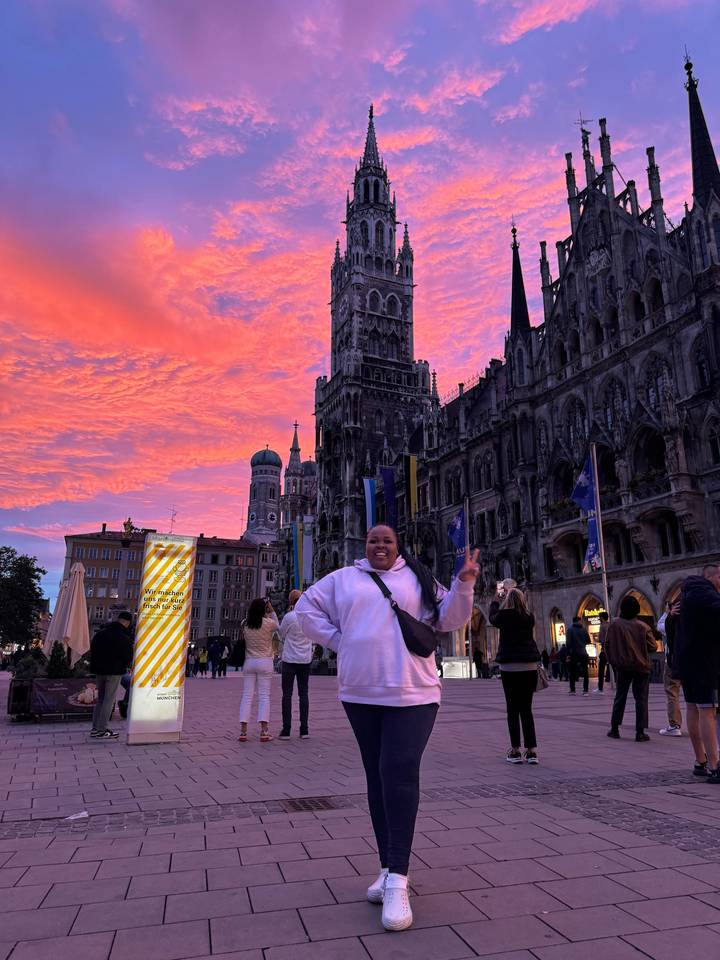 Individual posing in front of a cathedral at sunset.