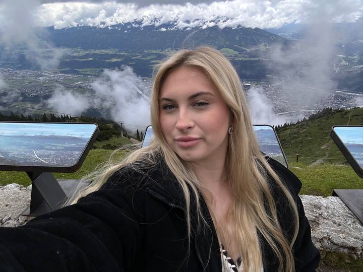 Woman posing at a mountain viewpoint with panels.