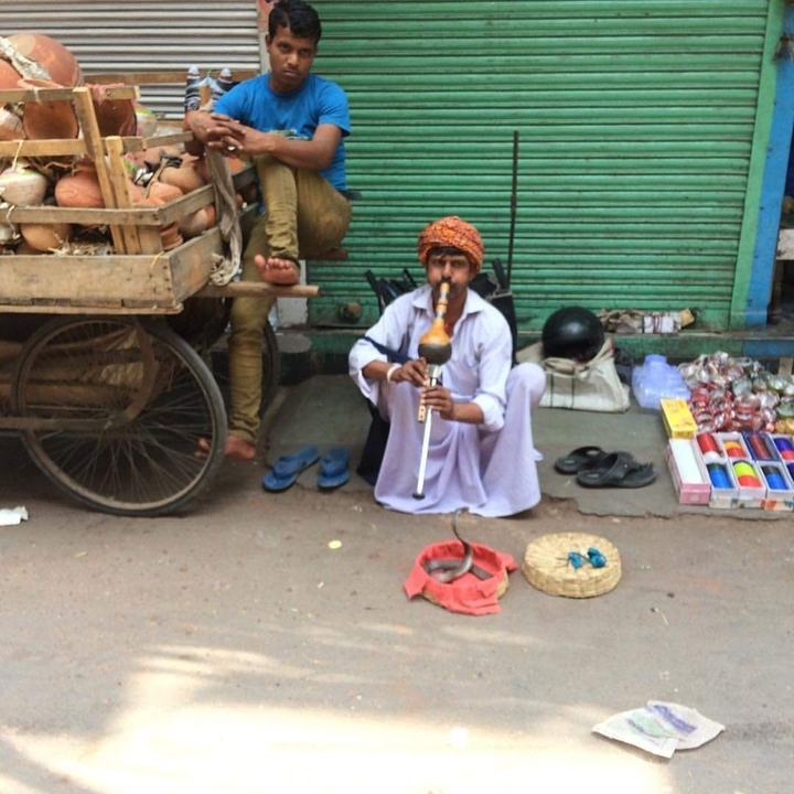 Artiste de rue jouant d'un instrument de musique traditionnel dans un marché animé.
