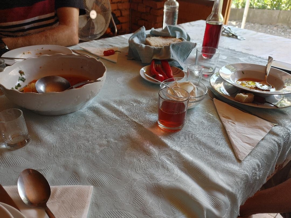 Table with dishes, glasses and leftover food.
