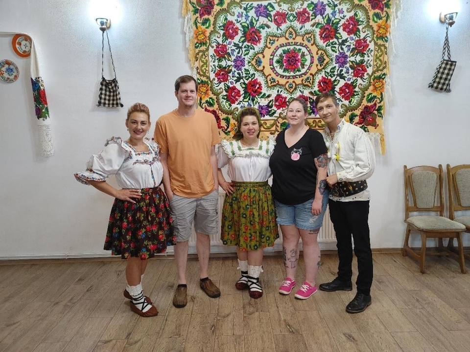 Group of people in traditional clothing smiling indoors.