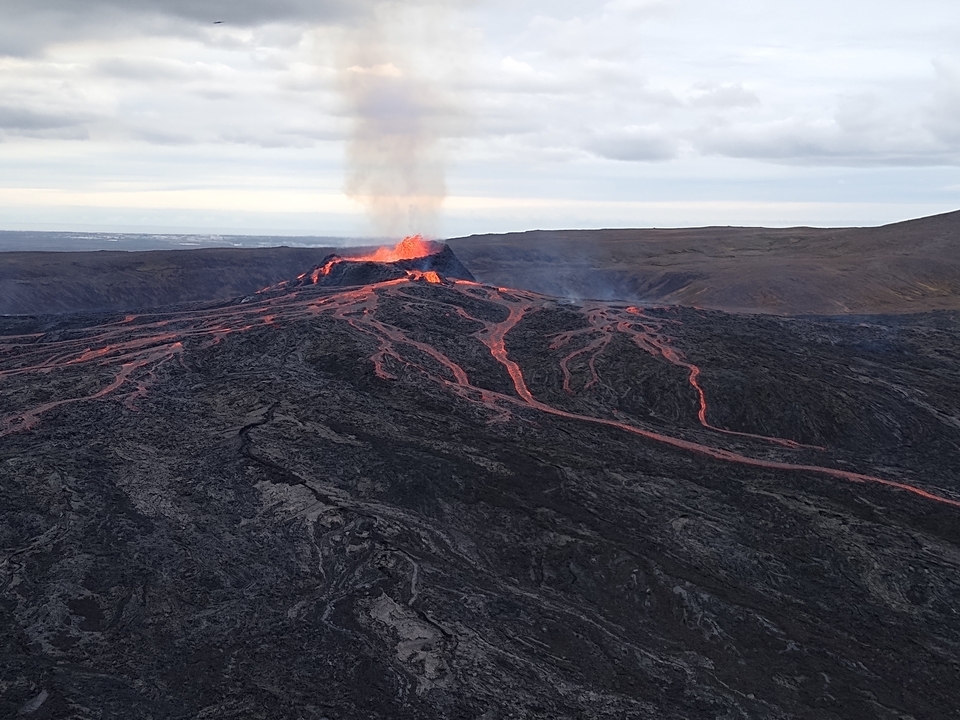 A volcanic eruption at a lava field setting, with glowing lava rivers.