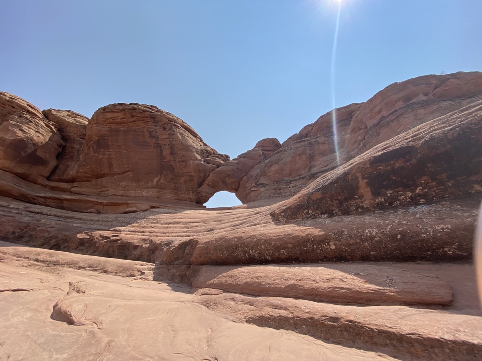 Rocky arch surrounded by red rock formations.