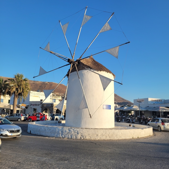 Windmill surrounded by people and buildings.