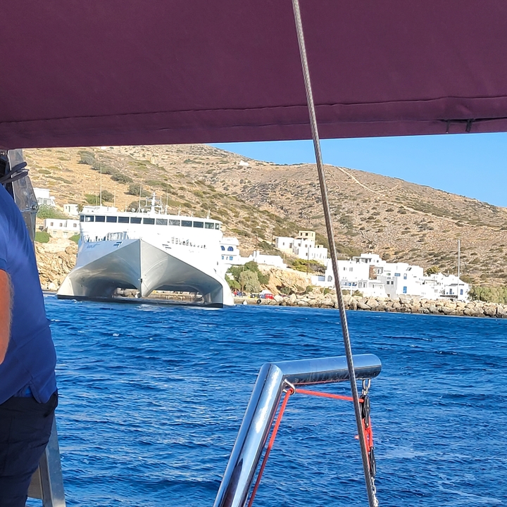 Large ferry boat approaching a coastal town.