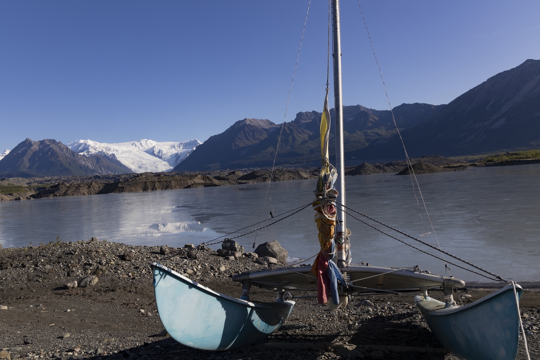 Sailboat on a lake with snowy mountains.