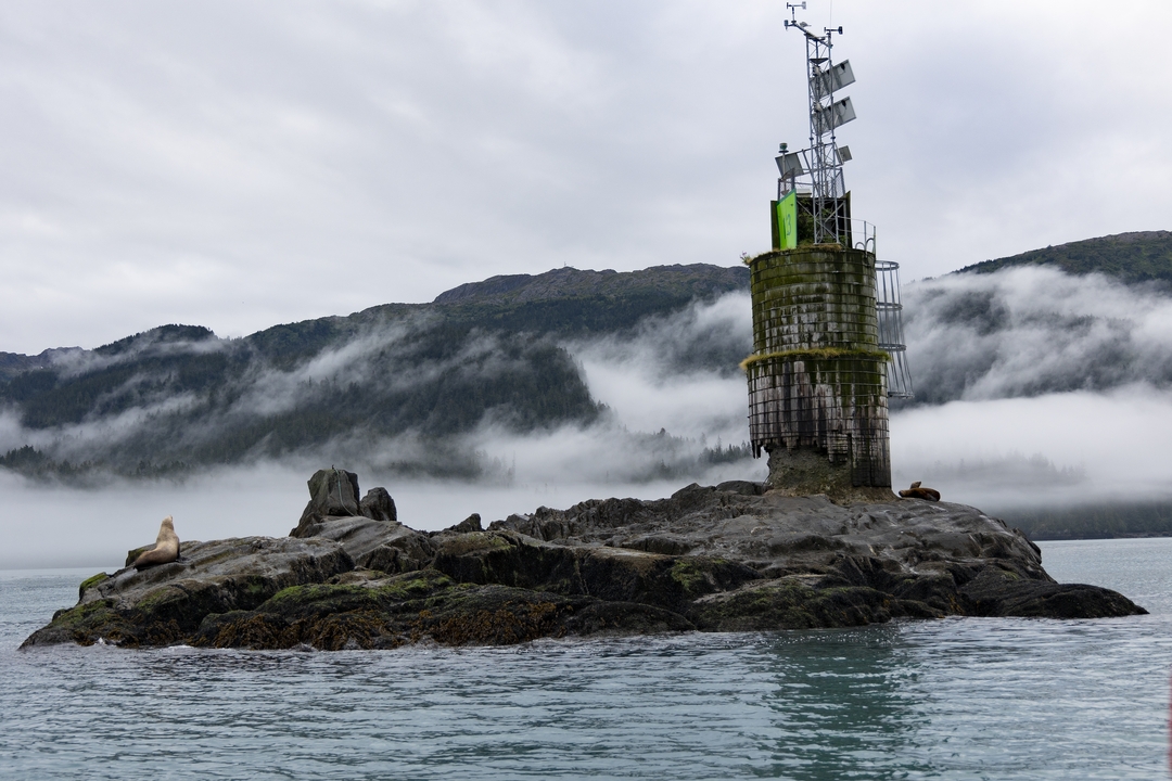 Foggy coastline with a lighthouse.