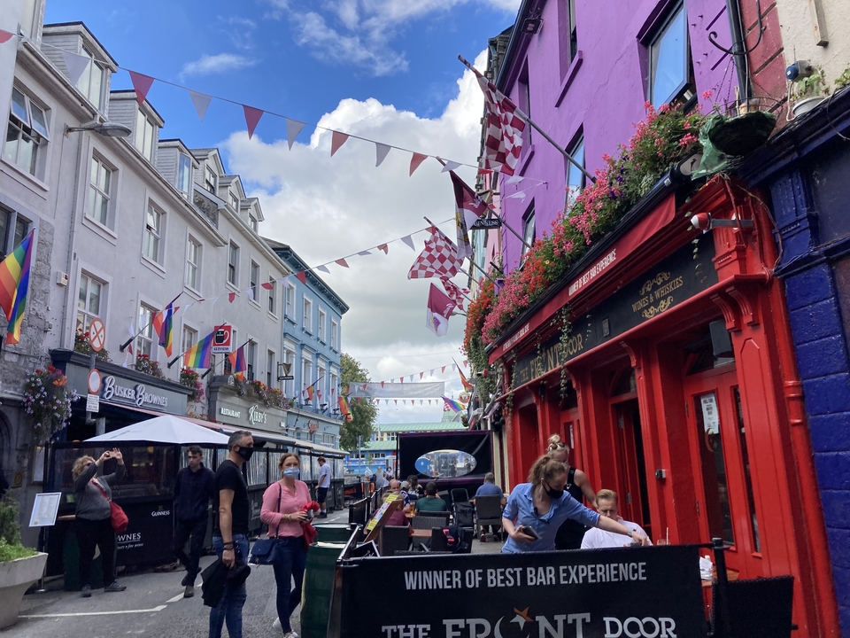 Busy street scene with colorful buildings and flags.