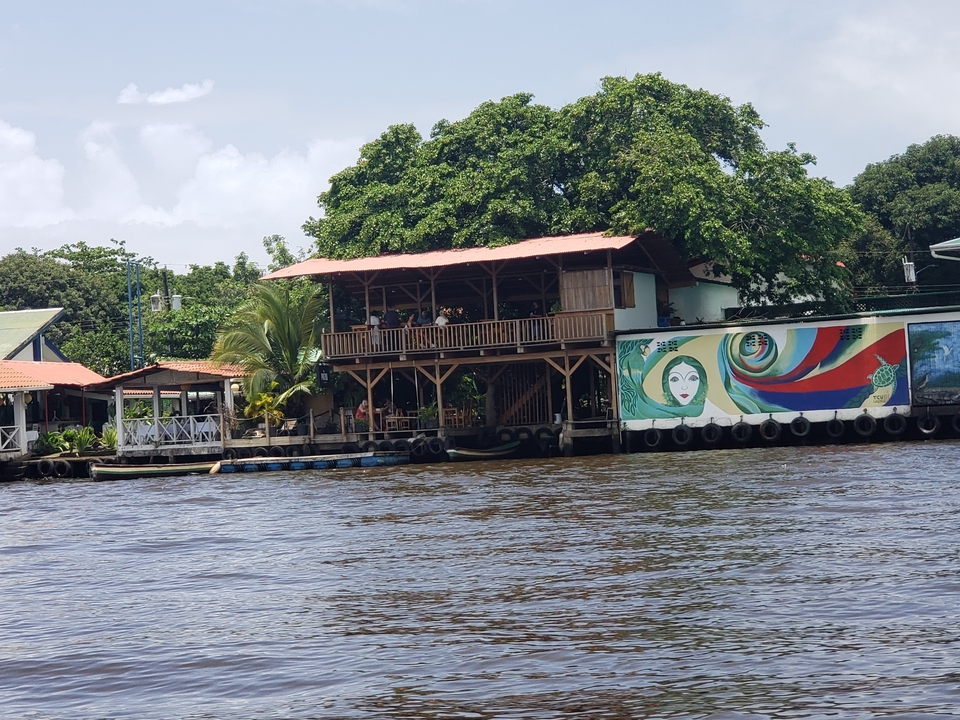 Colorful riverside restaurant with people dining.